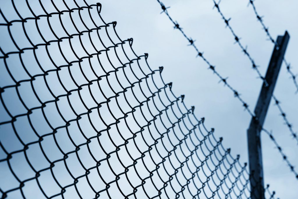 a chain link fence with barb wire on the top